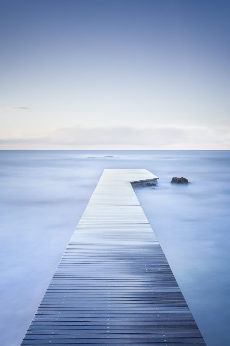 Wooden pier, rocks and calm sea on long exposure.